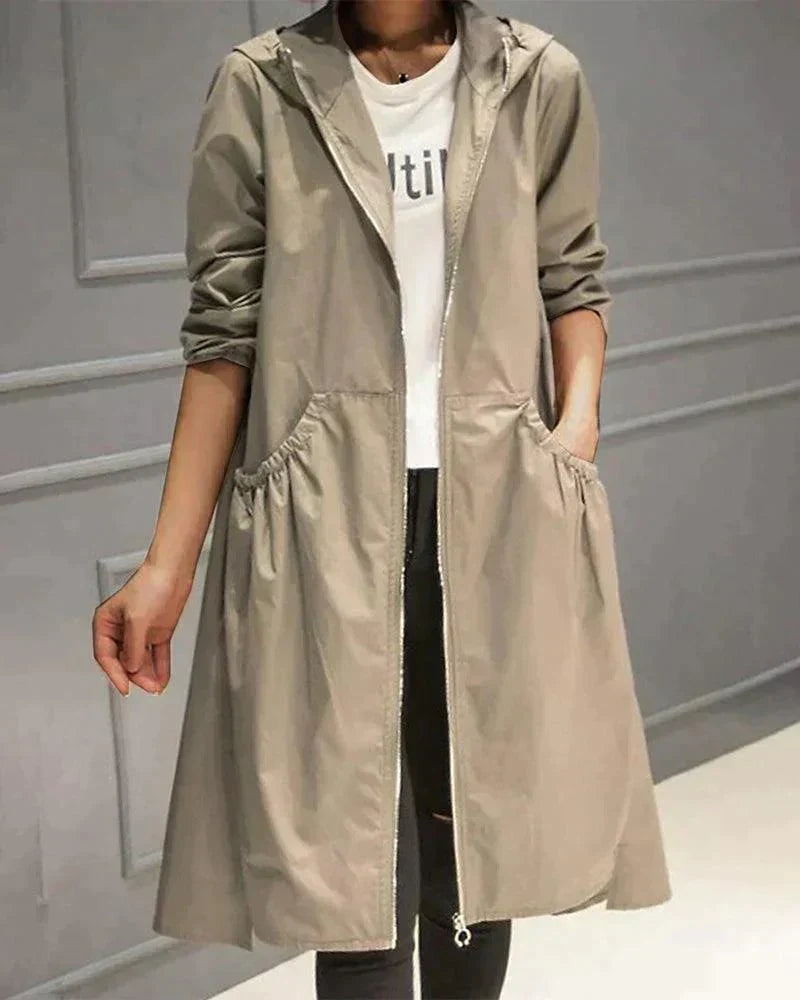 Modell trägt den offenen Regenmantel in Beige mit Kapuze und gerafften Eingrifftaschen, Vorderansicht 1