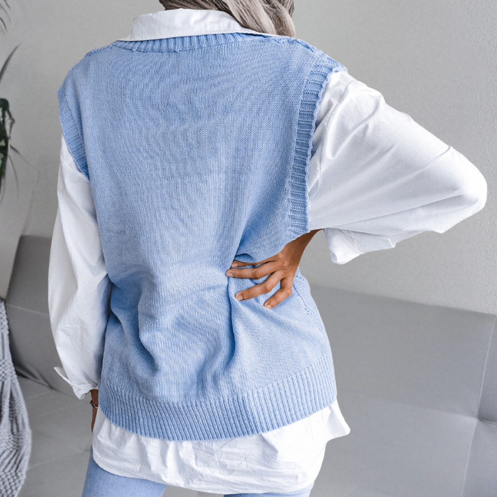 Frau in hellblauer Strickweste über weißer Bluse, modisch, lässig, eleganter Stil.