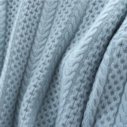 Hellblauer Strickstoff mit Zopfmuster, weiche Textur, ideal für Pullover und Wintermode.