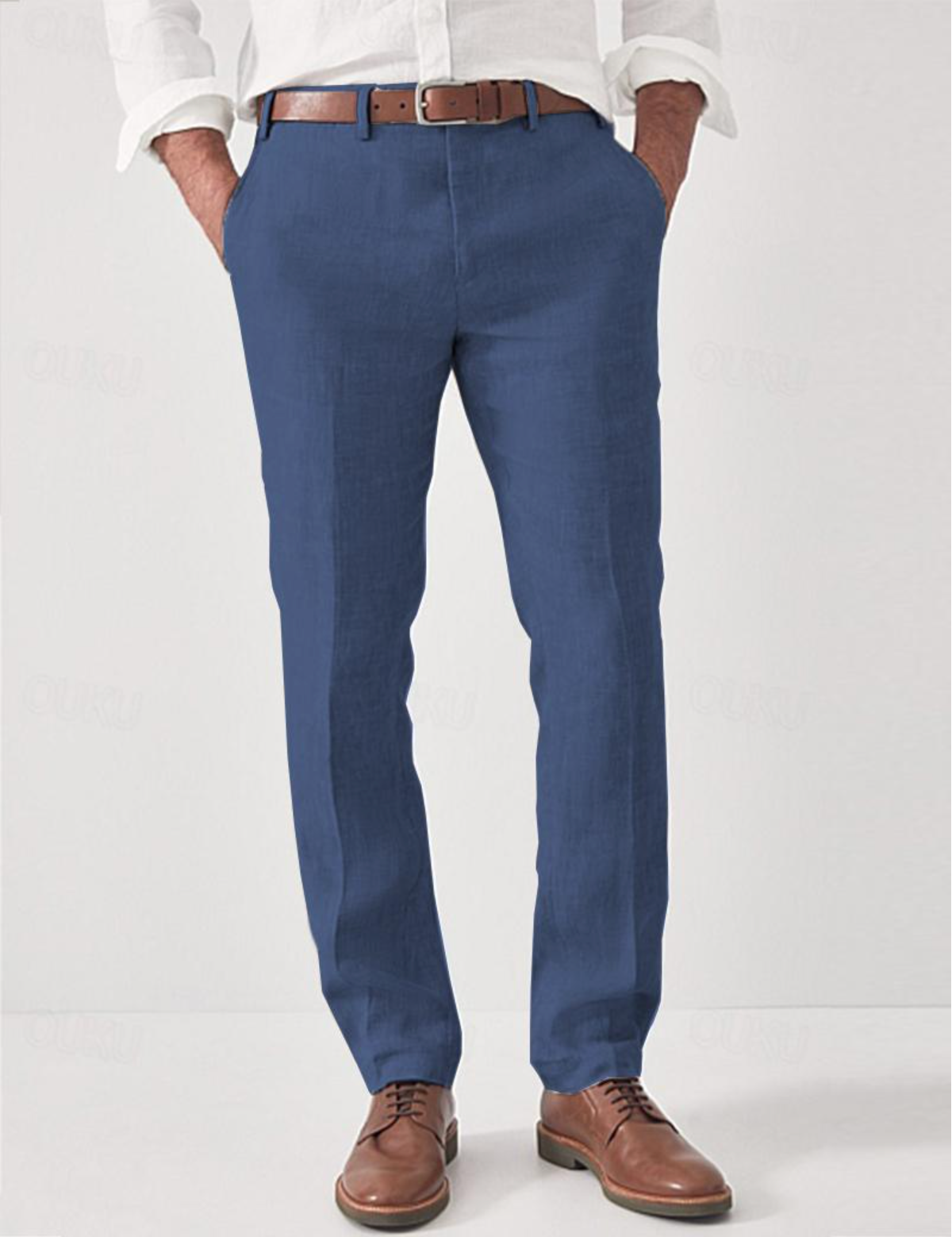 Blaue Leinenhose mit Gürtelschlaufen, andere Ansicht, am Model zu weißem Hemd, braunem Gürtel und braunen Lederschuhen gestylt.