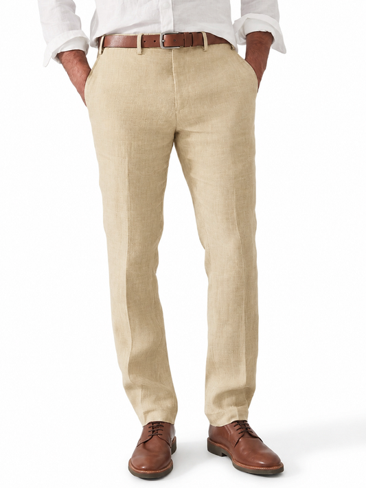Beige Leinenhose mit Bügelfalte, getragen von einem Mann mit weißem Hemd, braunem Ledergürtel und braunen Schnürschuhen, Hände in den Taschen.
