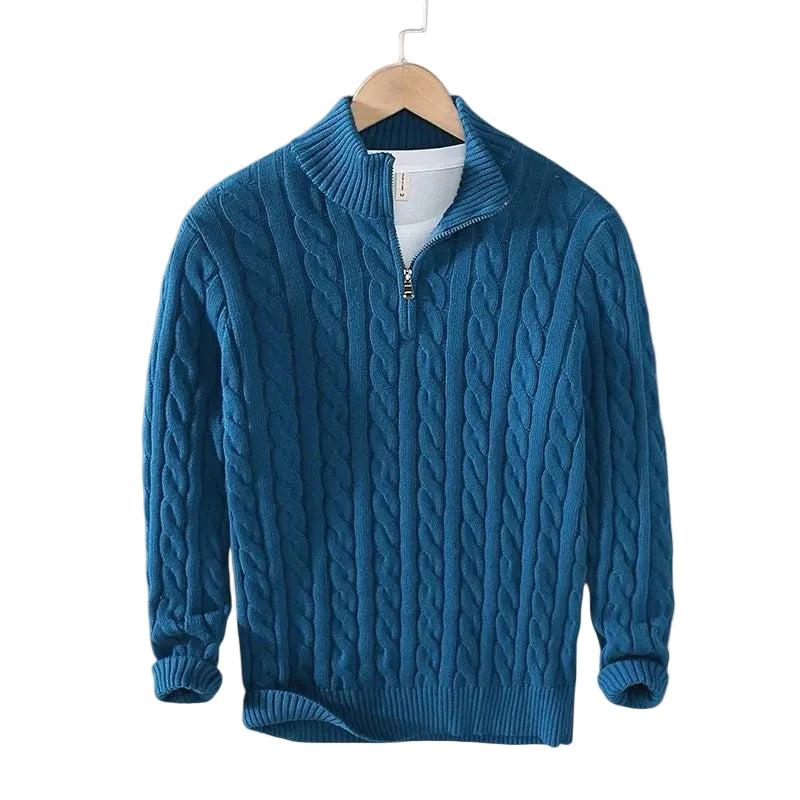 Petrolblauer Zopfstrick-Pullover mit kurzem Reißverschluss und Stehkragen auf einem Bügel, darunter ein weißes Shirt. 5