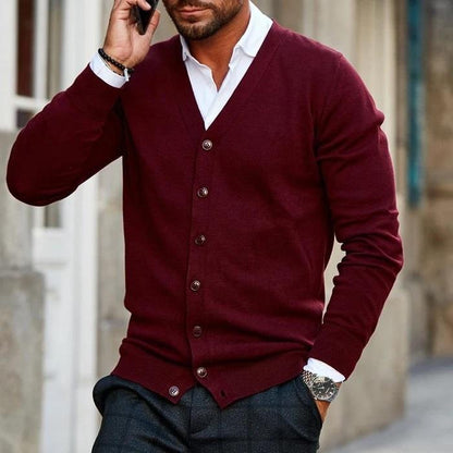Mann in bordeauxroter Strickjacke, V-Ausschnitt, Knöpfe, modisch, elegant, Herbstmode.