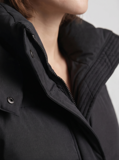 Nahaufnahme von Stehkragen, Reißverschluss, Druckknopf und Steppnähten der schwarzen Jacke am Model 7