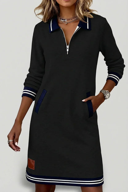 Schwarzes Kleid mit Streifenkragen und Reißverschluss vorn, marineblauen Besätzen an Taschen und Saum.