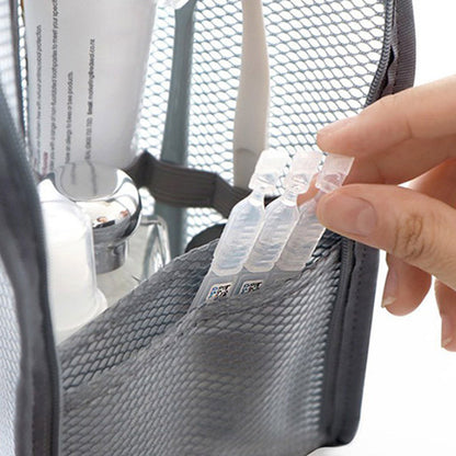Nahaufnahme der grauen Netztasche innen: Eine Hand zieht kleine Ampullen aus dem vorderen Netzfach, dahinter stehen Tube und Flaschen. 3