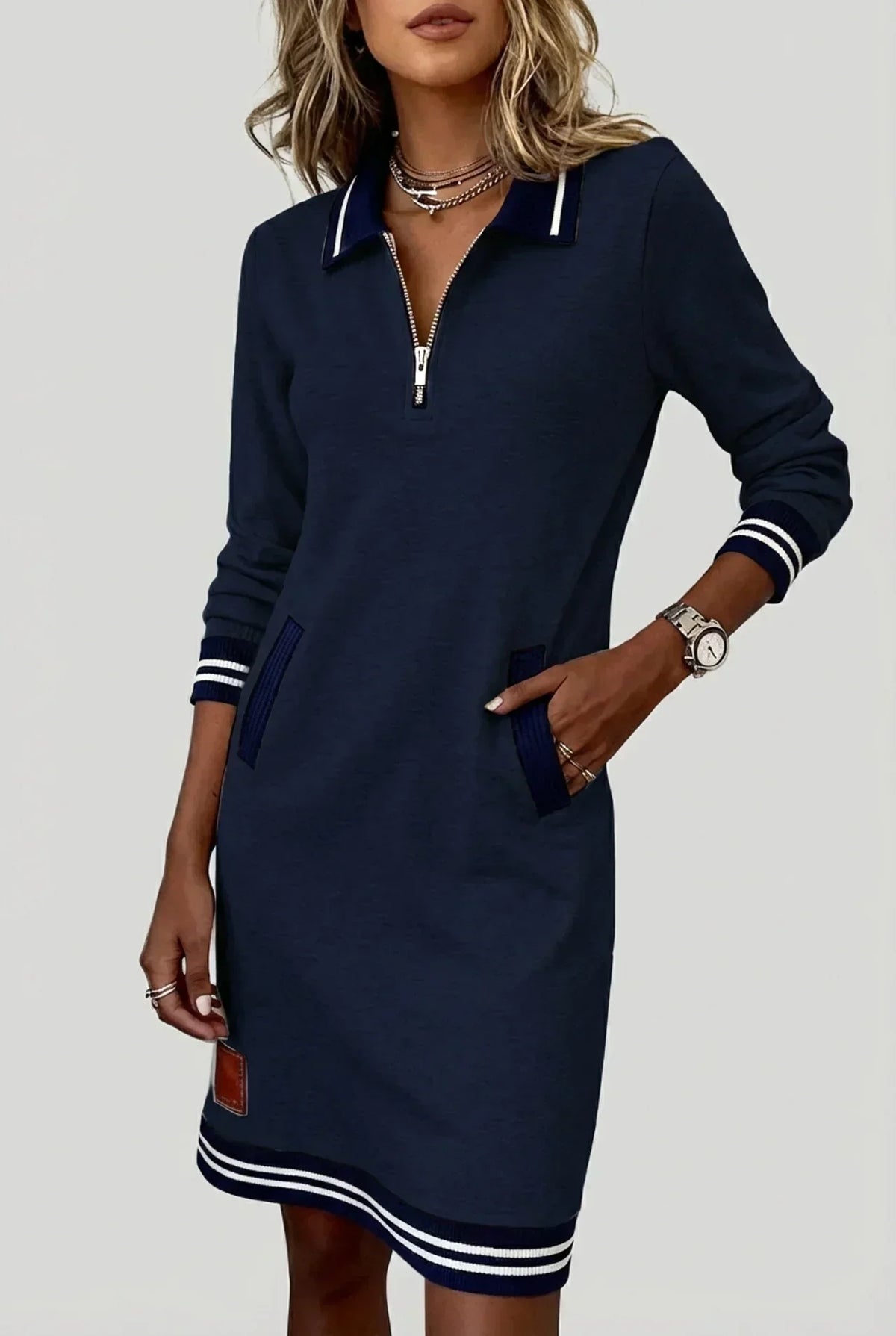 Marineblaues Kleid mit Streifenkragen, Reißverschluss vorn und Streifensaum, detail.