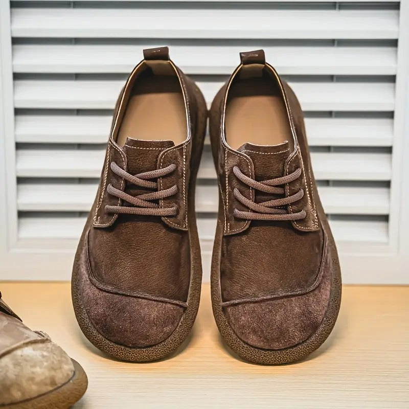 Dunkelbraune orthopädische Komfortschuhe mit heller Ziernaht und dicker Sohle, frontal.