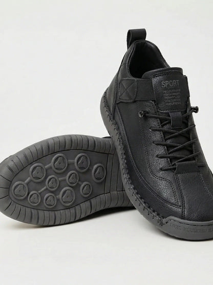 Schwarzer Sneaker mit grauer Sohle, ein Schuh aufgestellt, der andere zeigt das Sohlenprofil mit runden Noppen 1