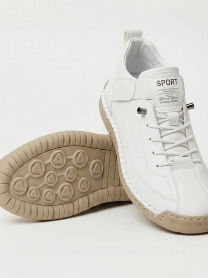 Weißer Sneaker mit beiger Sohle, ein Schuh steht schräg über dem anderen mit Sohlenansicht 4
