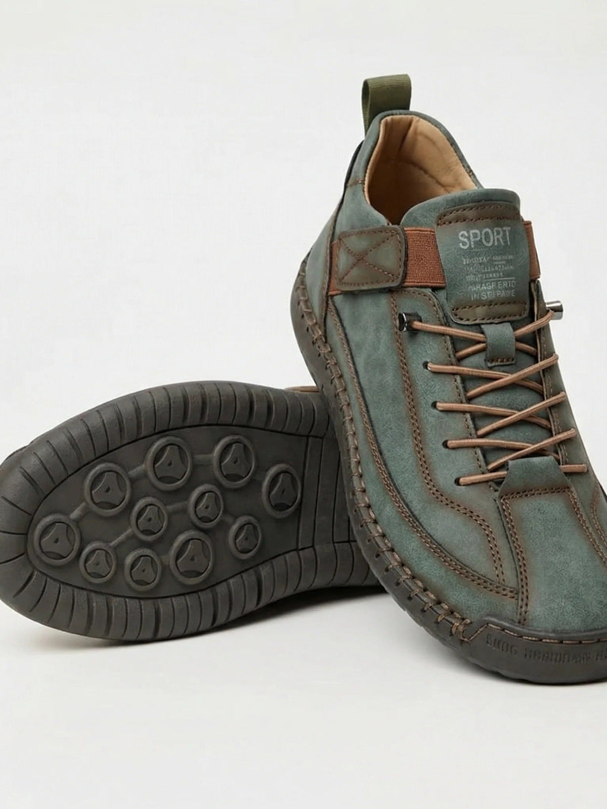 Graugrüner Sneaker mit braunen Schnürsenkeln und dunkler Sohle, ein Schuh gekippt 16