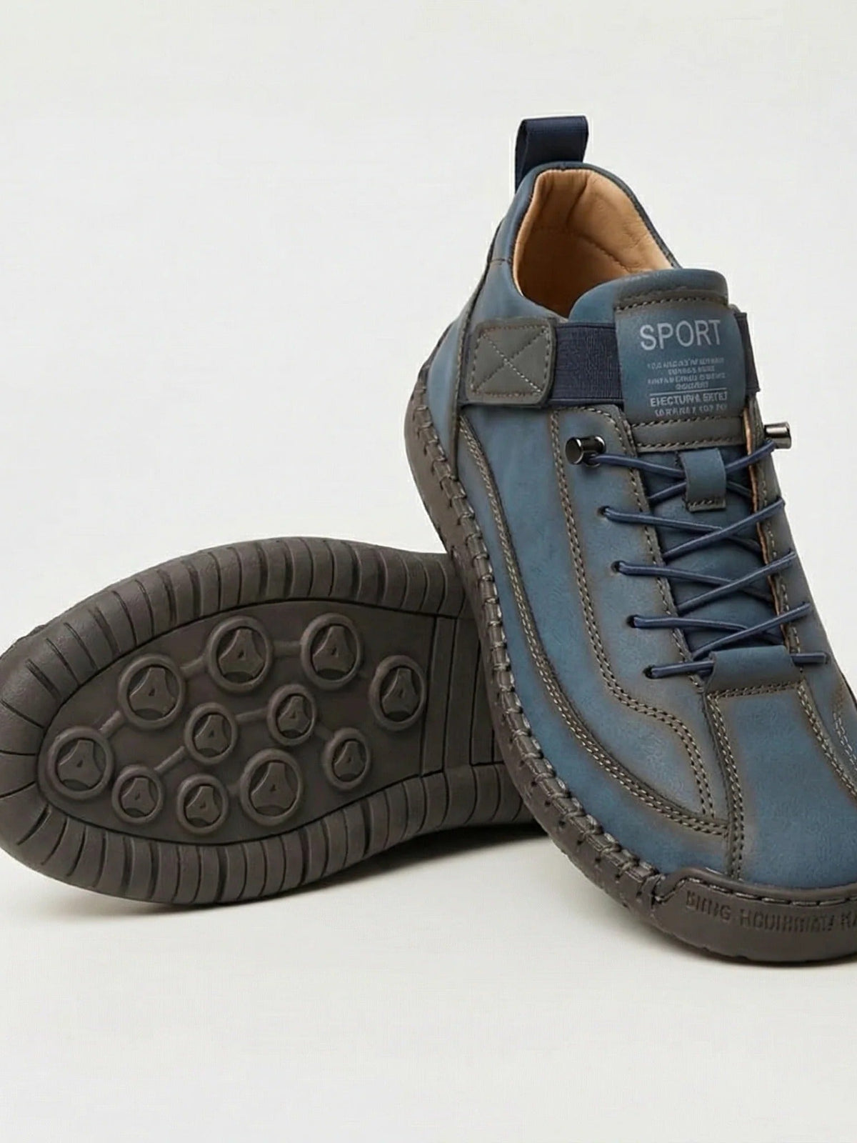 Blaugrauer Sneaker mit dunkler Sohle, ein Schuh gekippt zeigt das Noppenprofil der Sohle 8