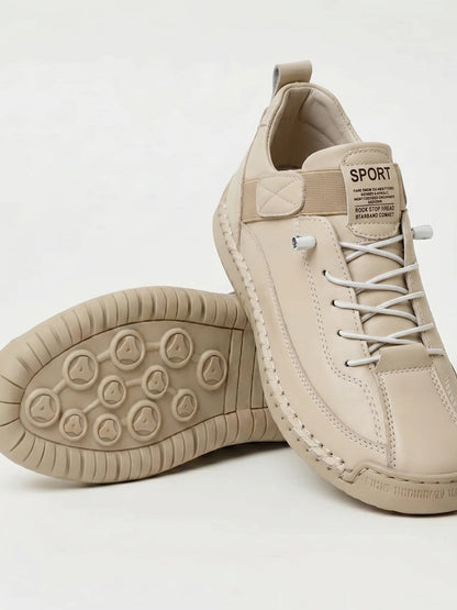 Beiger Sneaker mit weißen Schnürsenkeln, ein Schuh gekippt zeigt die gleichfarbige Sohle 12