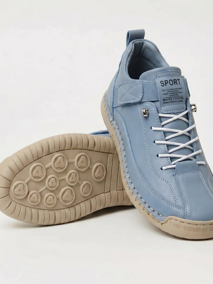 Hellblauer Sneaker mit weißen Schnürsenkeln und beiger Sohle, ein Schuh gekippt mit Sohlenansicht 19