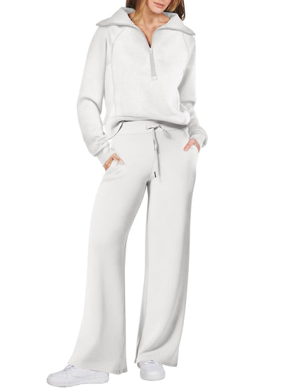 Frau in weißem Jogginganzug mit Reißverschluss, weite Hose, Freizeitmode, bequeme Kleidung.