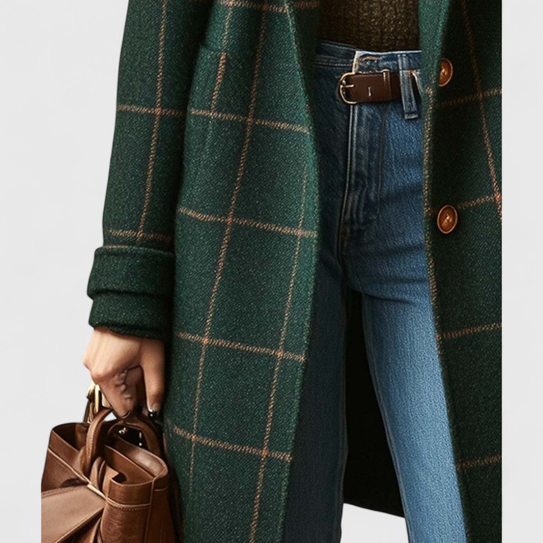 Detailaufnahme der Mantelvorderseite mit Knöpfen, aufgesetzter Tasche und umgeschlagenem Ärmel, dazu Jeans, Ledergürtel und braune Handtasche. 4