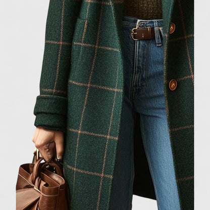 Detailaufnahme der Mantelvorderseite mit Knöpfen, aufgesetzter Tasche und umgeschlagenem Ärmel, dazu Jeans, Ledergürtel und braune Handtasche. 4