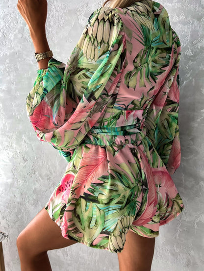 Frau in grün-rosa tropischem Kleid mit Blattmuster, Sommermode, elegantes Design.