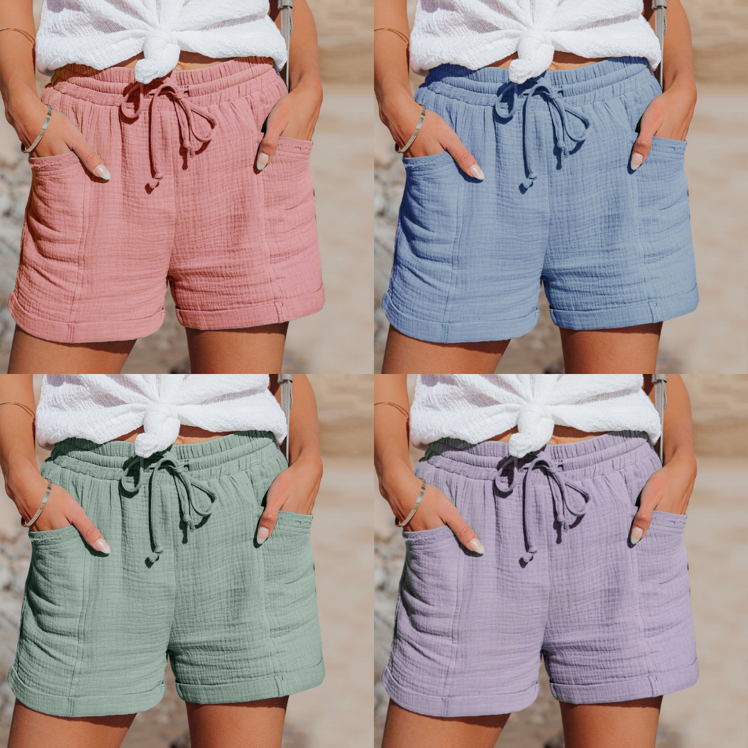 Vier Damen-Shorts aus Baumwolle in Rosa, Blau, Grün und Lila mit Kordelzug und Taschen.