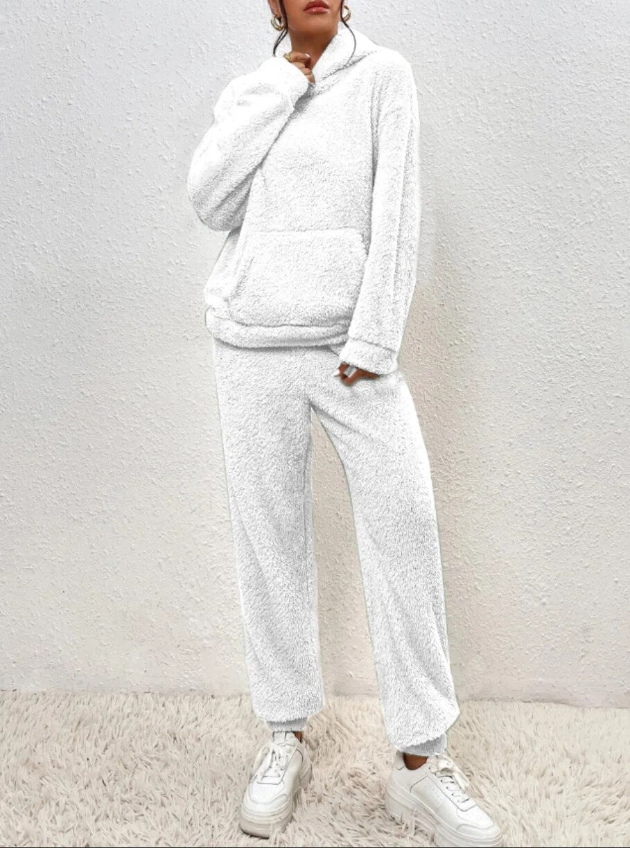 Frau in weißem Fleece-Hoodie und Jogginghose, gemütliche Wintermode, lässiger Stil.