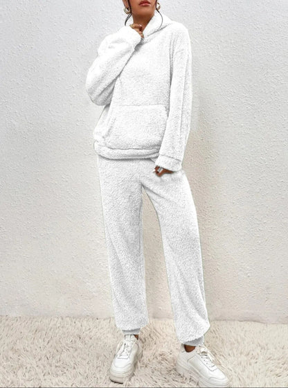 Frau in weißem Fleece-Hoodie und Jogginghose, gemütliche Wintermode, lässiger Stil.