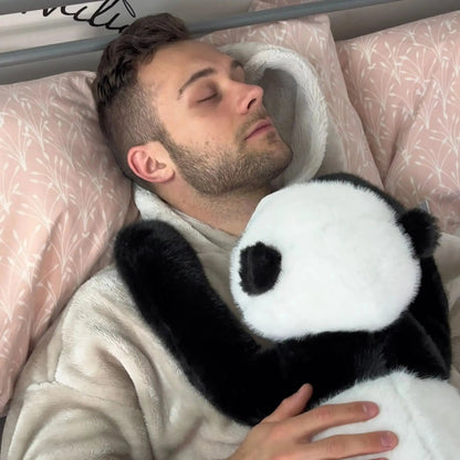 Schlafender Mann im Bett mit dem Panda-Plüschtier in den Armen