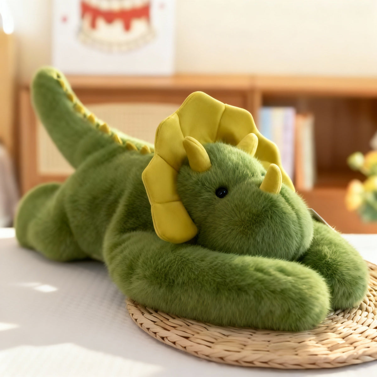 Grünes Drachen-Plüschtier mit gelbem Nackenschild und gelben Hörnern auf einer Bastmatte