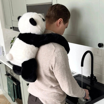 Detail des Panda-Plüschtiers mit langen Armen auf den Schultern eines Mannes in der Küche
