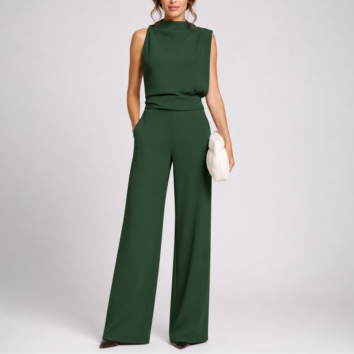 Ärmelloser Overall in Dunkelgrün mit hohem Kragen und weitem Bein, getragen von einem Model mit weißer Clutch 1