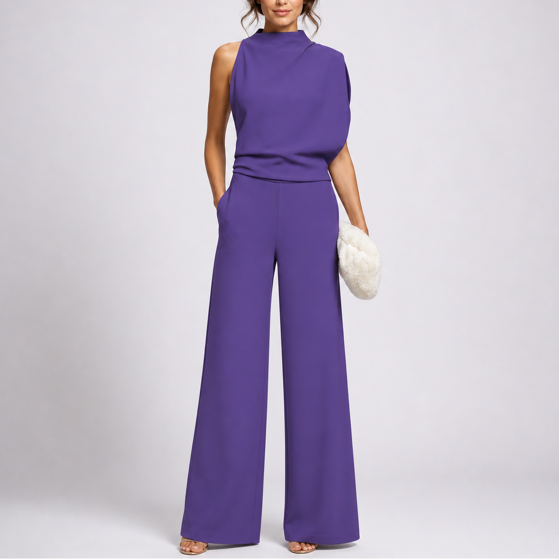 Violetter Overall mit hohem Kragen und weiten Beinen, vom Model mit heller Fellclutch und Sandaletten getragen 3