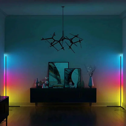 Zwei Eckstehlampen strahlen in Regenbogenfarben von Blau über Pink bis Gelb an die Wand eines Raums mit Sideboard und Kronleuchter. 4