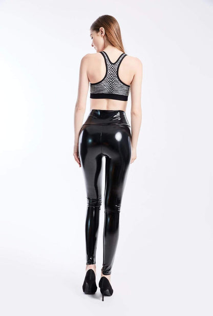 Frau in schwarzer, glänzender Kunstleder-Leggings und Sport-BH, Rückansicht, modisch, elegant.
