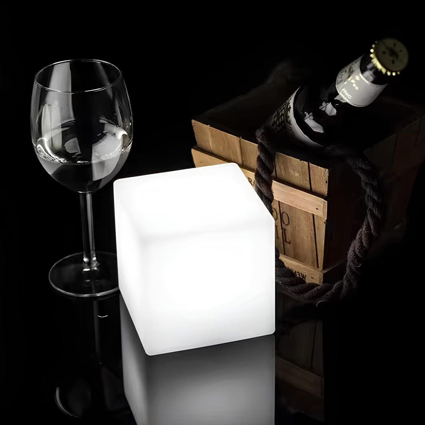 Leuchtender LED-Würfel, Weinglas, Holzkiste mit Flasche, stilvolle Dekoration, Nachtlicht.