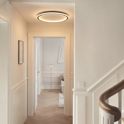 Schwarze runde LED-Deckenleuchte, weitere Ansicht im Flur.