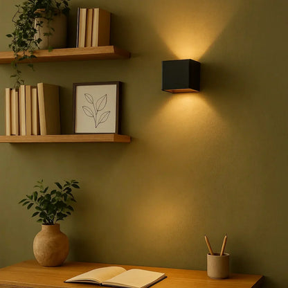Schwarze Wandleuchte an olivgrüner Wand über einem Schreibtisch mit Regalen, Pflanze und aufgeschlagenem Buch 9