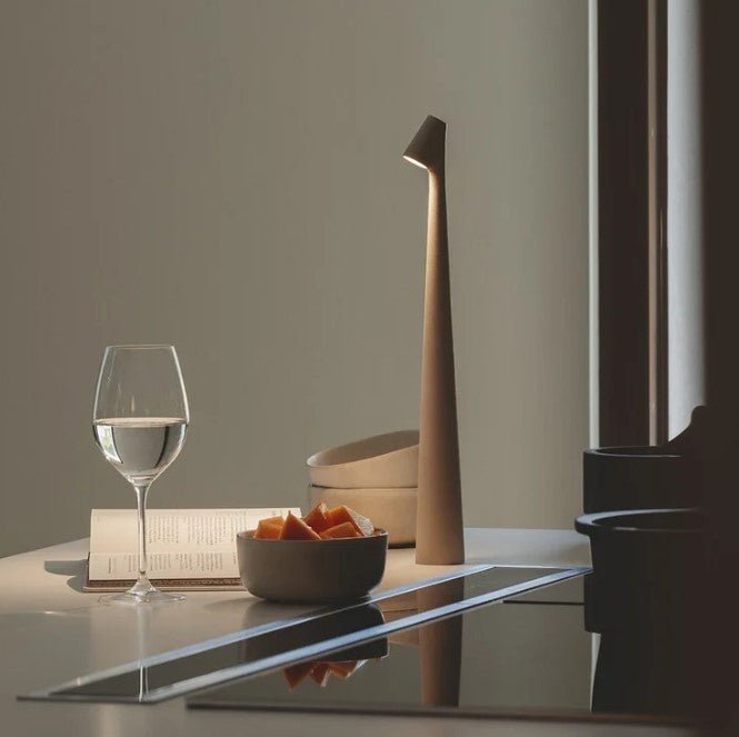 Wiederaufladbare LED-Tischlampe, weitere Ansicht auf einem Tisch neben Glas und Buch.