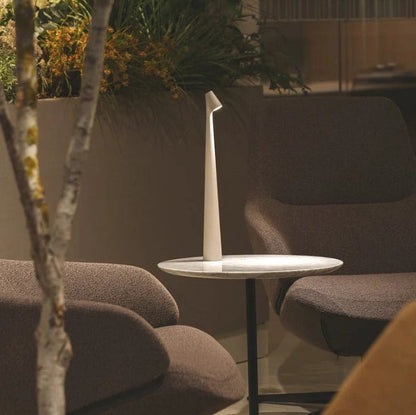 Wiederaufladbare LED-Tischlampe, weitere Ansicht auf einem Tisch zwischen zwei Sesseln.