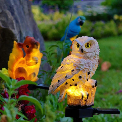 Leuchtende weiße Eule im Garten neben einem orangefarben leuchtenden Eichhörnchen und einem blauen Papagei.