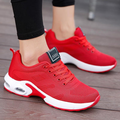 Rote Sneaker in Nahaufnahme von der Seite mit weißer Sohle, Luftpolster und Schnürung.