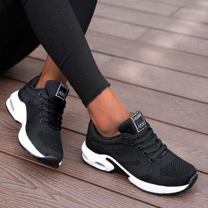 Schwarze Strick-Sneaker mit weißer Sohle und Luftpolster, getragen zu schwarzer Leggings.