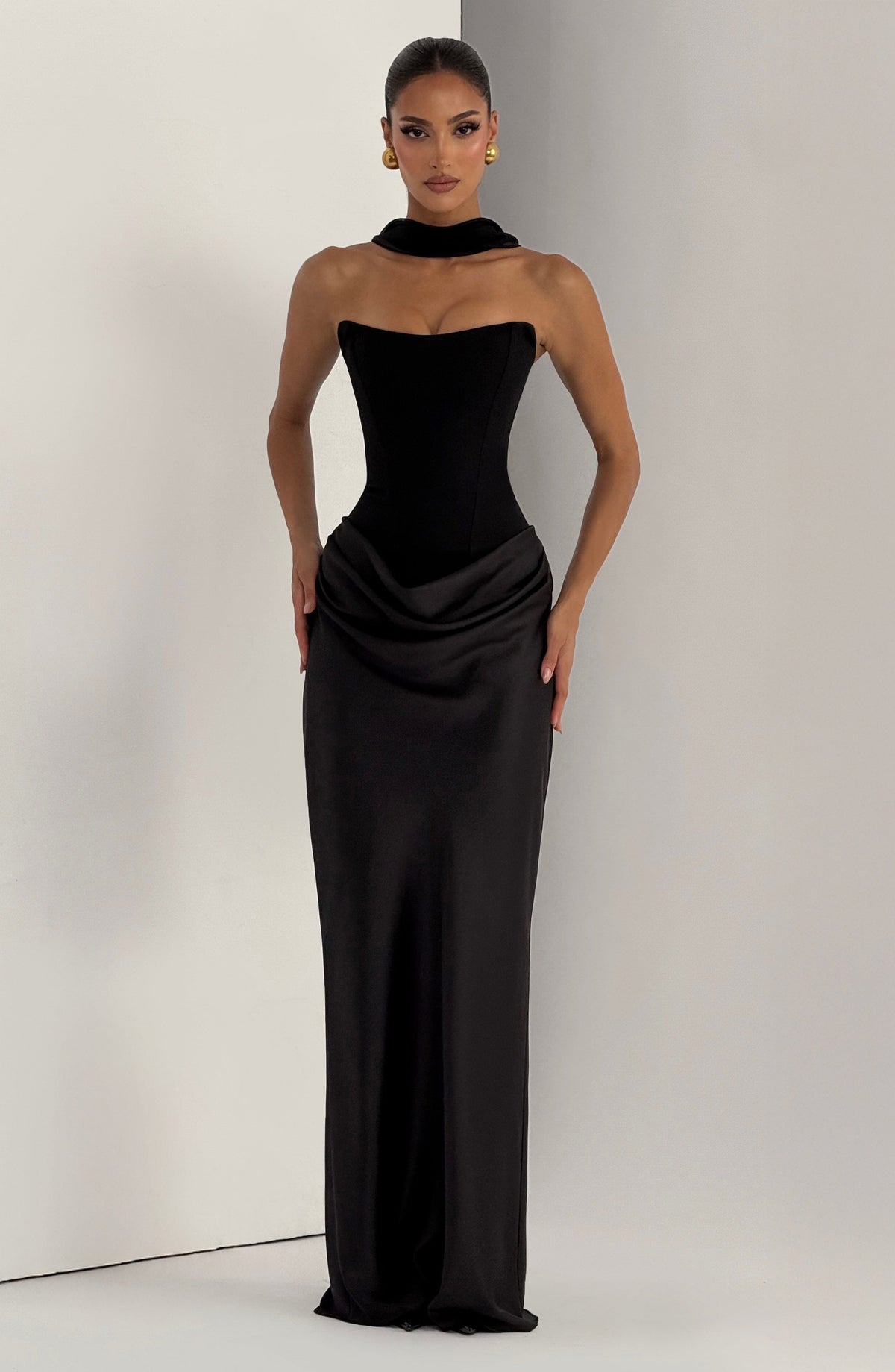 Schwarzes Kleid mit Kragenband am Hals, Frontansicht am Model vor hellem Wandhintergrund 26