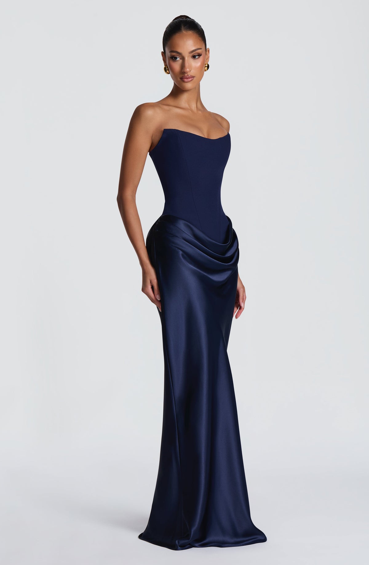 Model im marineblauen Korsett-Maxikleid, Dreiviertelansicht von der Seite mit fließend drapiertem Satinrock 43