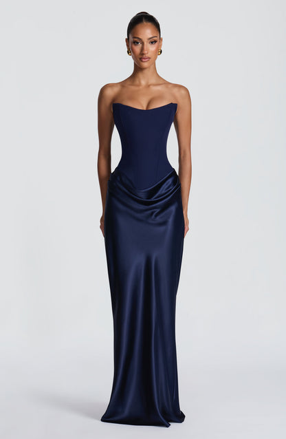 Model trägt das trägerlose Maxikleid in Marineblau, Frontansicht mit Korsage und glänzendem Satinwasserfallrock 42