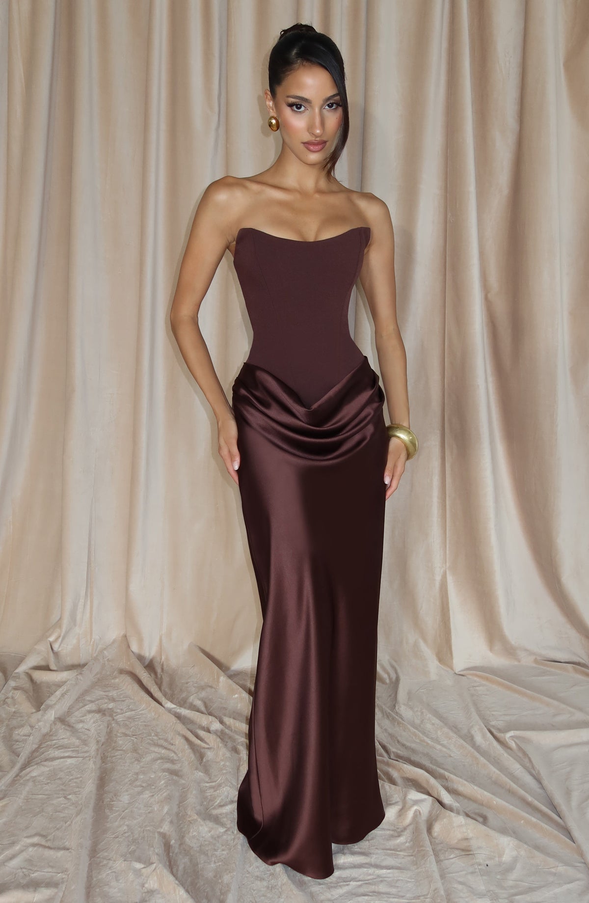 Braunes Korsettkleid vor beigem Vorhang, Model mit Hand an der Hüfte 8