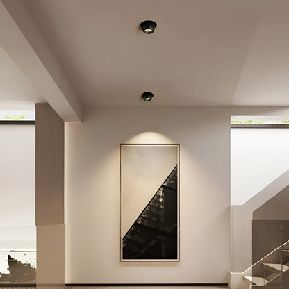 Zwei schwarze Einbaustrahler an der Flurdecke setzen ein gerahmtes Wandbild neben der Treppe in Szene 3