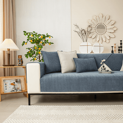Grüner Sofabezug auf einem Sofa im Wohnzimmer mit Kissen und Zimmerpflanze