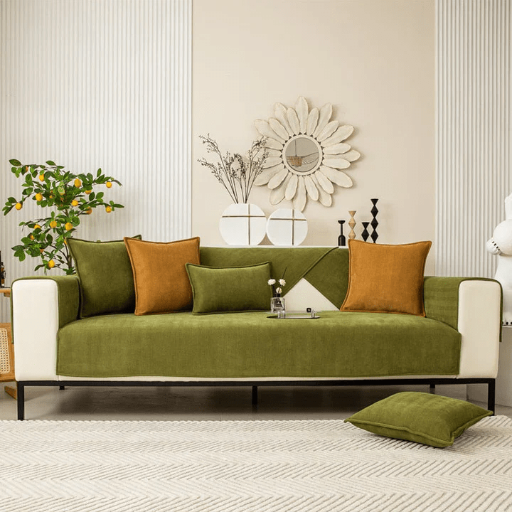 Grüner Sofabezug auf einem dreisitzigen Sofa im hellen Wohnzimmer