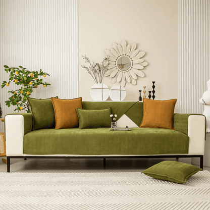 Grüner Sofabezug auf einem dreisitzigen Sofa im hellen Wohnzimmer