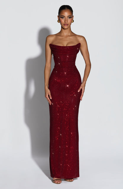 Model trägt das trägerlose Kleid in Dunkelrot, Vorderansicht mit Strasssteinen, drapiertem Oberteil und goldenen Ohrringen. 1