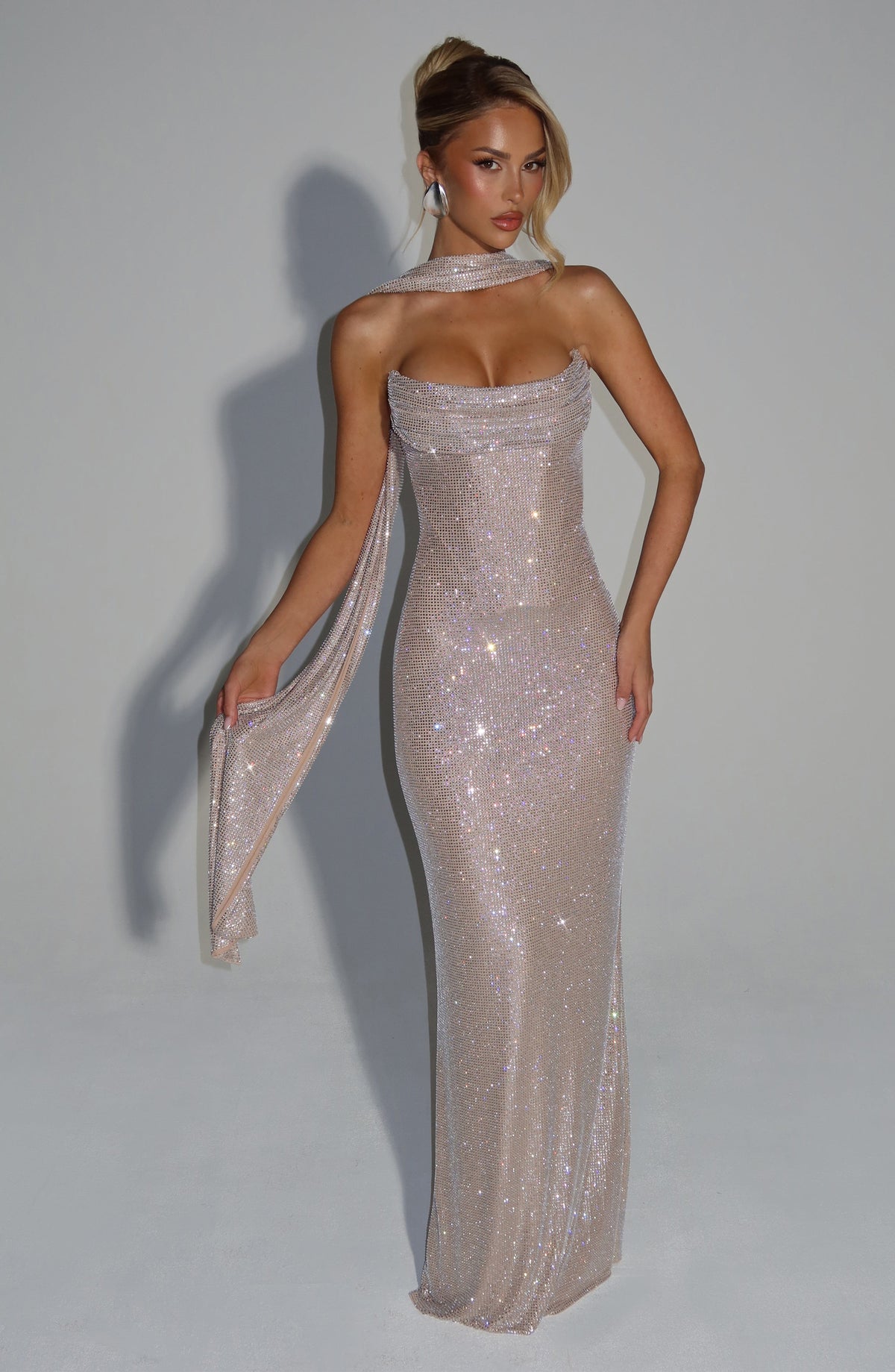 Champagnerfarbenes Kleid mit Strasssteinen, dazu ein langer Schal-Streifen um die Schulter, den das Model in der Hand hält. 17